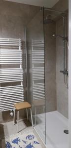 a glass shower with a stool in a bathroom at Valparaiso Koksijde in Koksijde