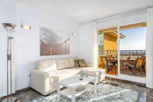 een woonkamer met een witte bank en een tafel bij Seaview flat in Fuengirola Ref 67 in Fuengirola