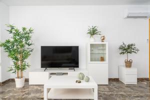 een woonkamer met een tv en planten bij Seaview flat in Fuengirola Ref 67 in Fuengirola