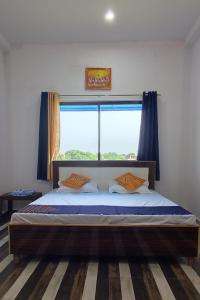 a bedroom with a bed with a large window at Kashi Nest Homestay in Varanasi