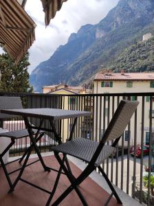uma mesa e cadeiras numa varanda com vista para uma montanha em qu4ttro em Riva del Garda
