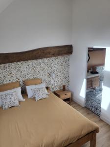 1 dormitorio con 1 cama grande y 2 almohadas en Charmante maison près du canal, en Tinténiac