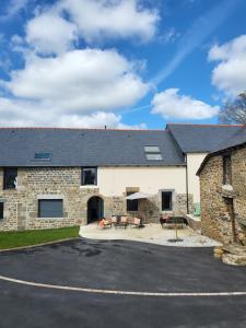 - un bâtiment en pierre avec un parking en face dans l'établissement Charmante maison près du canal, à Tinténiac