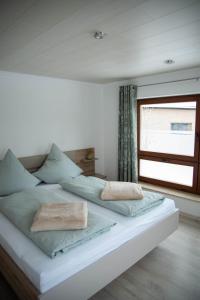 een groot wit bed met 2 kussens erop bij Ferienhaus Sehmatal in Sehmatal