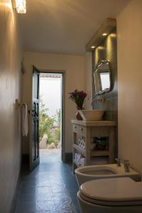 a bathroom with a sink and a toilet and a mirror at Cielo Arriba Casa in Humahuaca