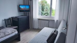 a bedroom with a bed and a television on a dresser at Apartament Trzy Pokoje in Zamość