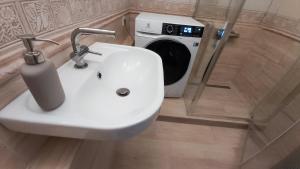 a bathroom with a sink and a washing machine at Apartament Trzy Pokoje in Zamość +19 photos