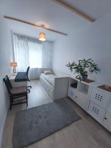 a room with a bed and a desk and a chair at Apartament Trzy Pokoje in Zamość