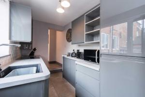 a white kitchen with a sink and a microwave at Impressive Apartment in Derby in Derby