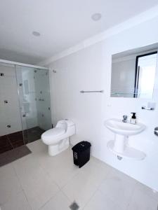 a white bathroom with a sink and a toilet at Apartamento en Cali - Cuarto de Legua in Cali