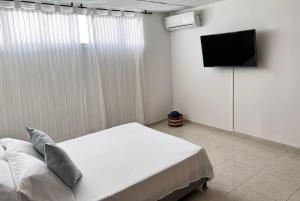 a bedroom with a bed and a flat screen tv at Apartamento en Cali - Cuarto de Legua in Cali