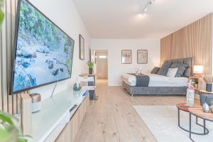 a living room with a bed and a large screen tv at Apartment Wesseling in Wesseling