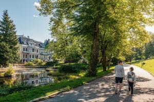 a man and a child walking down a path near a river at Inner City Center in Bergen