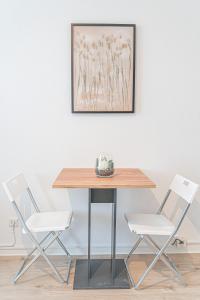 stół z dwoma krzesłami i zdjęciem na ścianie w obiekcie Apartment Wesseling w mieście Wesseling