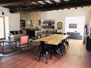 una sala de estar con una gran mesa de madera y sillas en Maison Céleste en Nuits-Saint-Georges