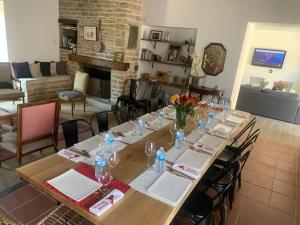 una mesa larga con sillas y una habitación con chimenea en Maison Céleste en Nuits-Saint-Georges