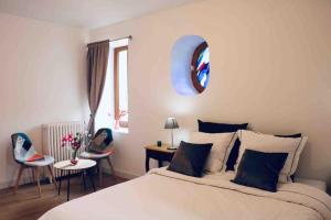 a bedroom with a bed and chairs and a mirror at Maison Céleste in Nuits-Saint-Georges +65 photos