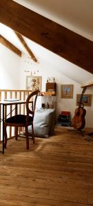 a living room with a chair and a guitar at gite du pré in Gorron