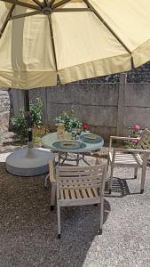 a table and chairs under a large umbrella at gite du pré in Gorron