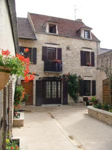 an old brick house with black doors and flowers at Maison Céleste in Nuits-Saint-Georges