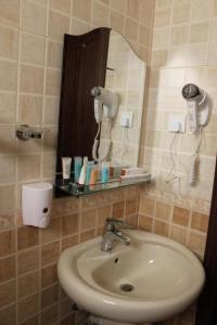 ein Bad mit einem Waschbecken und einem Spiegel in der Unterkunft Plaza Home in Khobar