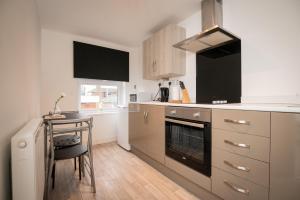 cocina con mesa y fogones horno superior en Immaculate Apartment meters from the beach en Great Yarmouth