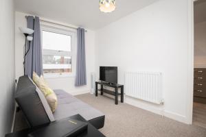 sala de estar con sofá y TV en Immaculate Apartment meters from the beach en Great Yarmouth