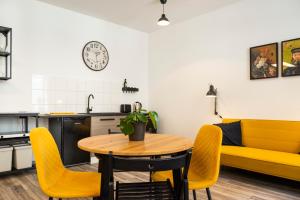 eine Küche und ein Esszimmer mit einem Tisch und gelben Stühlen in der Unterkunft Studio am Malerweg Altstadt Pirna in Pirna
