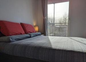 a bedroom with a bed with a large window at Luxury One Bedroom Flat in Deptford in London