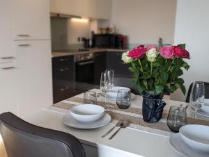 a kitchen with a table with a vase of roses at Luxury One Bedroom Flat in Deptford in London