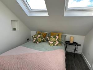 a bedroom with a bed with pillows in a attic at Lovely New Decor Studio - 4 The Southwell in London