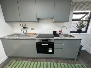 a kitchen with a sink and a stove top oven at Lovely New Decor Studio - 4 The Southwell in London