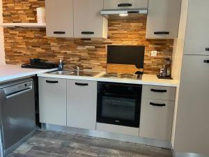 a kitchen with a sink and a stove top oven at Appartement T2 - 1er étage in Seysses