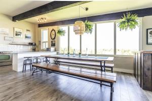 a large kitchen with a table and some windows at Mountain View-Backyard-Air-Conditioning-BBQ-15mins walk Blue Mountain Village in Blue Mountains