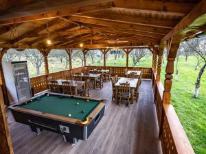 a pool table in a pavilion with tables and chairs at Drag de Maramureș in Ocna Şugatag
