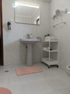 a white bathroom with a sink and a mirror at Casa em Palmela - Setúbal in Palmela