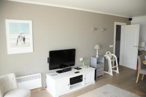 ein Wohnzimmer mit einem Flachbild-TV an der Wand in der Unterkunft Scorpio 0702 in Nieuwpoort