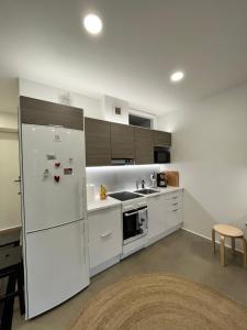 a white kitchen with a refrigerator and a sink at Pikku Flora in Kokkola