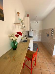 una cocina con una mesa de madera y un jarrón de flores en La Casa di Diana en Montecchio