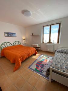 1 dormitorio con 1 cama con manta naranja y sofá en La Casa di Diana en Montecchio