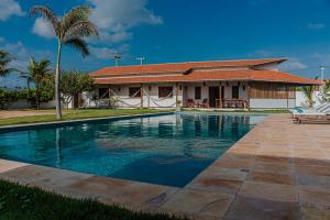 a swimming pool in front of a house at Vila Tao in Fortim