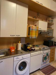 a kitchen with a washing machine and a sink at il rifugio della cava in Orvieto