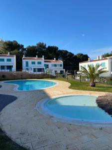a swimming pool in a yard with buildings in the background at Casa Prainha, Alvor para 10 pessoas in Alvor