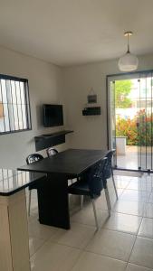 a dining room with a table and chairs and a television at Privê estrela in Porto De Galinhas