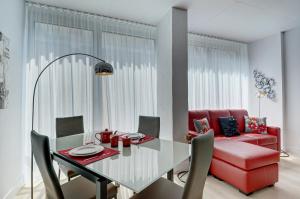 a dining room with a table and a red couch at Les Immeubles Charlevoix - Le 760-507 in Quebec City +5 photos
