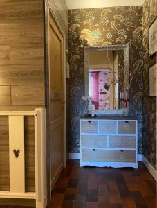 ein Badezimmer mit einer Kommode und einem Spiegel in der Unterkunft Landhaus Fay B&B in Bad Ischl