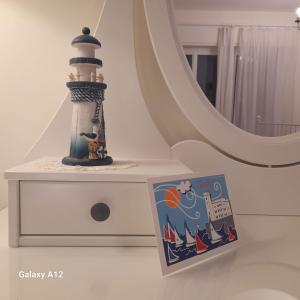 un faro de juguete sentado en un tocador junto a un espejo en Trieste Mia Rooms en Trieste