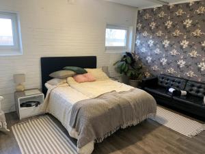 1 dormitorio con 1 cama grande y 1 sofá en Alingsgård - B&B, Gårdshotell, Spabad, Bastu, Gym, Padelbana en Löderup