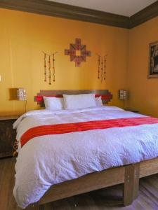 ein Schlafzimmer mit einem großen Bett mit einem Kreuz an der Wand in der Unterkunft CASA HOSPEDAJE EL LABRADOR in Cusco