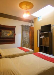 a hotel room with two beds and a tv at CASA HOSPEDAJE EL LABRADOR in Cusco